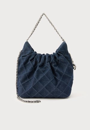 Τσάντα χειρός από σκουρό μπλε καπιτονέ ύφασμα με ρυτιδωτό επάνω μέρος και ασημένια αλυσίδα λουράκι στον ώμο, σε απλό φόντο.