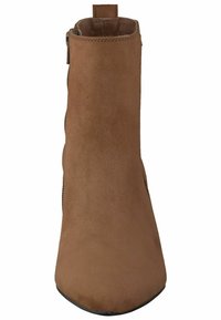 Bottine en daim marron avec un bout pointu, une silhouette élancée, une fermeture éclair latérale et une finition texturée.