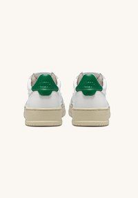 Sneakers bianchi in pelle con dettagli verde sul tallone, linguetta testurizzata e suola in gomma beige, che evidenziano un design minimalista e linee pulite.