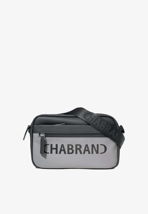 Bolso pequeño rectangular bandolera en negro y gris con bolsillo delantero con cremallera y correa negra ancha con el nombre de la marca impreso.