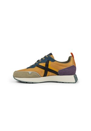 Zapatillas con una mezcla de materiales en amarillo, azul, beige y púrpura; parte superior de malla, acentos de gamuza, suela intermedia blanca gruesa y detalle de raya negra.