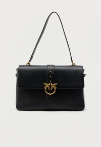 Μαύρη δερμάτινη τσάντα χειρός με λαβή στην κορυφή, κούμπωμα σε σχήμα χρυσού πουλιού και διακοσμητικό με τρουκς στο λουρί της εμπρόσθιας πτυχής, σε απλό λευκό φόντο.