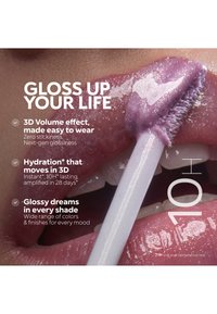 Nahaufnahme von Lippen, die glänzenden, schimmernden violetten Lipgloss mit Applikator auftragen und dabei Feuchtigkeit, Volumen und Farbvielfalt betonen.