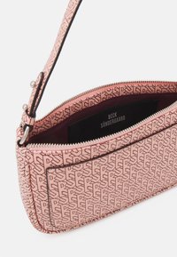 Różowa torebka kopertówka w wzory z zamkiem błyskawicznym, o gładkiej powierzchni, cienkim pasku oraz ciemnym wykończeniu wnętrza. Logo widoczne wewnątrz.