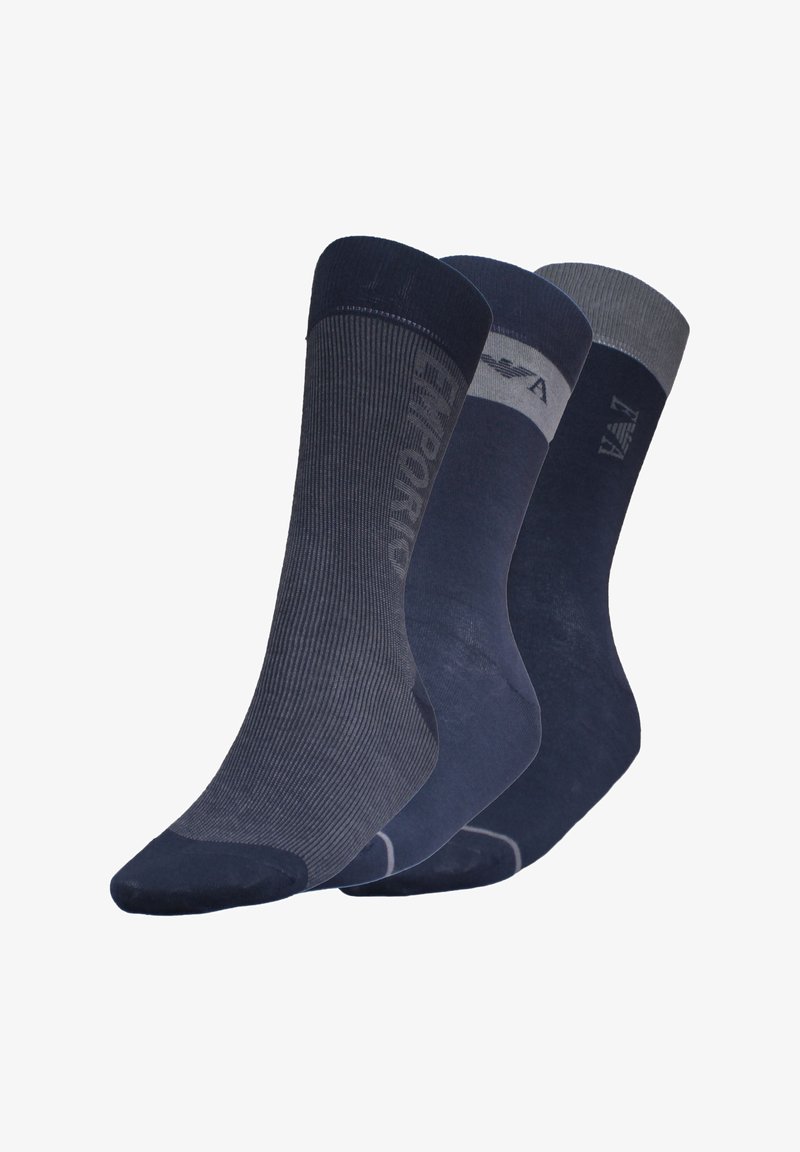 Tres pares de calcetines azul marino: uno con canalé, uno liso y uno con un puño gris. Cada par presenta un sutil logo en el lateral.