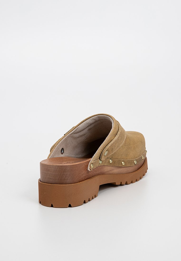 Sabot en daim beige avec semelle en bois, clous en laiton sur le côté et semelle en caoutchouc à motif, vu de l'angle droit arrière.