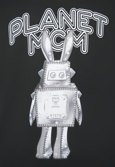 Robot u obliku šivane srebrne zeke s MCM logotipima i tekstom "PLANET MCM" iznad na crnoj pozadini.