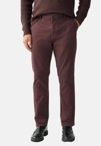 Pantaloni din bumbac burgundy cu o croială clasică, față plată, două buzunare laterale, închidere cu nasture și o textură netedă. Asortați cu mocasini negri.