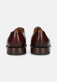 Braune Lederschuhe mit glatter Oberfläche, runder Form, niedrigem Absatz und subtilen Nähdetails an der Rückseite. Klassisches Design.