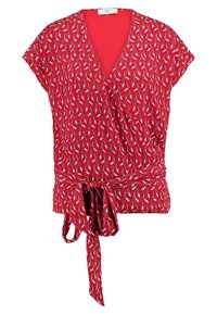 Červený top s krátkými rukávy, vzorovaný bílými hvězdicovitými tvary, s detailem na zavázání v pase a hlubokým výstřihem do V.