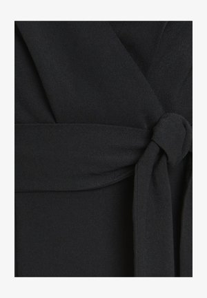Zwarte stof met een soepele textuur, een geraffineerd ontwerp en een strikdetail in de taille. Het materiaal lijkt lichtgewicht en valt soepel.