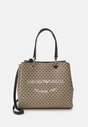 Beżowa torba typu tote z powtarzającym się wzorem logo orła Emporio Armani, czarne uchwyty z srebrnymi łańcuszkami oraz biały napis "EMPORIO ARMANI MILANO 1981" na froncie.