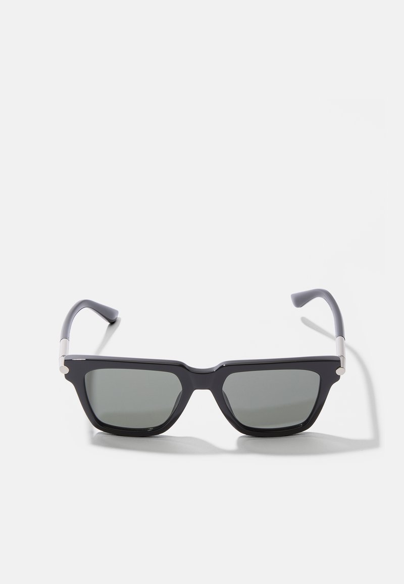 Occhiali da sole neri rettangolari con lenti grigie tintate, dettagli in metallo sulle aste e bracci in plastica liscia con una finitura opaca.