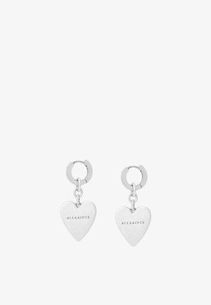 Silver heart-shaped earrings with a polished finish, featuring a hanging design and a small hoop attachment. Engraved brand name "ALLSAINTS."