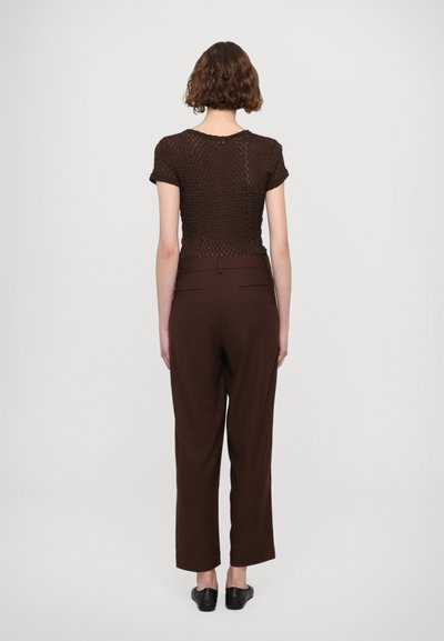 Brown knitted top with short sleeves paired with high-waisted, loose-fitting brown trousers. Simple design, smooth texture, and tailored fit.
