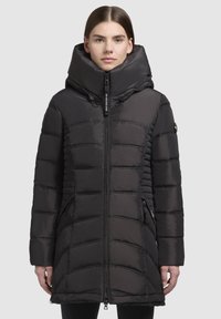 Manteau rembourré noir avec un col montant, fermeture éclair et poches latérales. Présente un motif matelassé horizontal et une texture lisse et brillante.