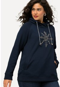 Navy modrá mikina s kapucí se vzorem sněhové vločky, detaily na šňůrkách a bočními kapsami. Měkká tkanina s volným střihem.