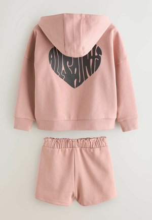 Rosa Baumwoll-Hoodie mit einem großen schwarzen herzförmigen Logo auf der Rückseite, kombiniert mit passenden Shorts mit elastischem Bund.