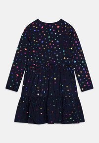 Dlouhý rukáv šaty z námořnické tkaniny s barevnými hvězdnými vzory, s nažehlenou sukni a kulatým výstřihem. Měkký, texturovaný materiál.
