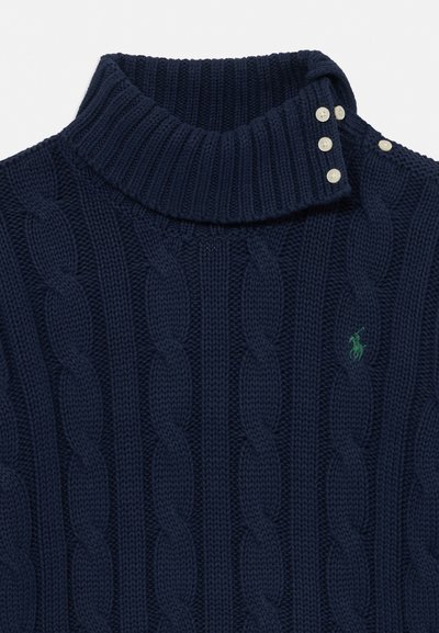 Temno modra pulover z visokim ovratnikom in kitasto pletenino, stranskim zapiranjem z gumbi ter majhnim zelenim vezenim logotipom na prsih.