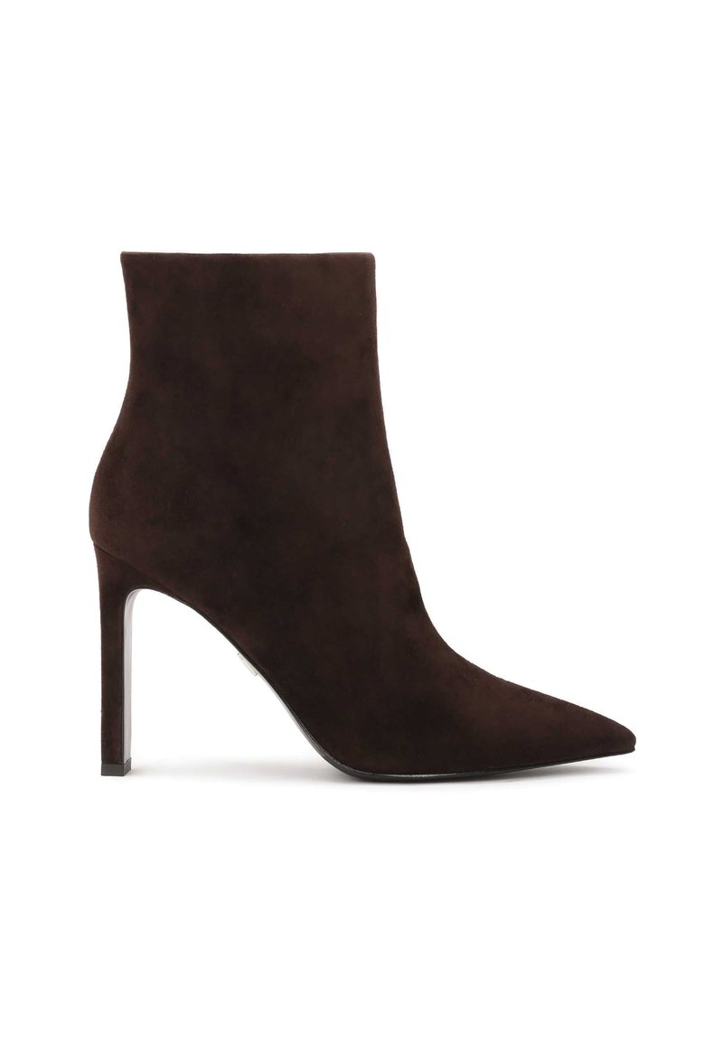 Brūni zamšādas potīšu zābaki ar norādītu purngalu un augstu stiletto papēdi. Gluda tekstūra un minimālistisks dizains bez redzamām aparatūrām vai rotājumiem.