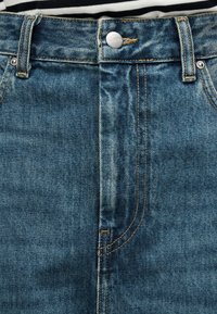 Μπλε τζιν παντελόνι με ψηλή μέση, διαθέτει κλείσιμο με μεταλλικό κουμπί, χρυστό ράψιμο και μπροστινές τσέπες. Υφασμα με υφή και απαλή ξεθώριαση.