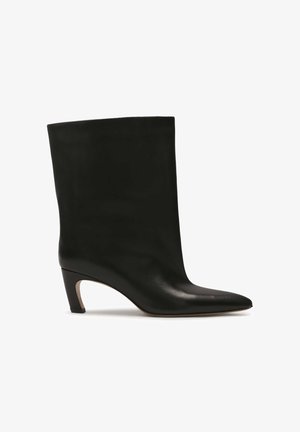 Sorte læder ankelstøvle med spids tå og afsmalnet hæl, der har en glat overflade og sømløst design.