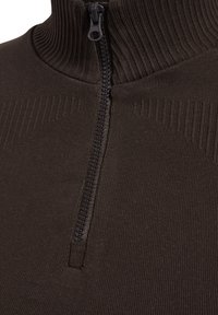 Mörkbrun zip-up tröja med hög ribbad krage och en fin ribbad struktur. Har en svart dragkedja framtill.