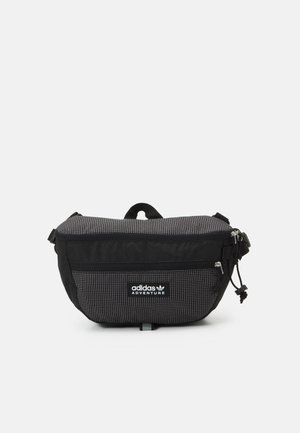Zwart-grijze Adidas Adventure heuptas met voorvak met rits en verstelbare band, weergegeven tegen een effen witte achtergrond.