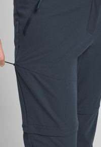 Marine softshell broek met verstelbare zijklem, ritszakken en een gladde textuur. Voorzien van versterkte stiksels en een getailleerde pasvorm.