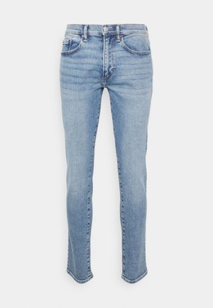 Svetlo modré denimové džiny so slim fit strihom, dizajnom s piatimi vreckami a mierne roztrhnutým lemom. Obsahuje klasický gombík a zips.