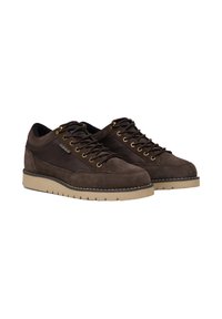 Sneaker in suede marrone con un pannello in tessuto testurizzato, occhielli dorati e suola in gomma beige. Presentano lacci piatti e dettagli cuciti.
