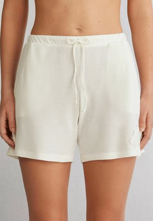 Witte, geweven tricot shorts met een elastische tailleband en trekkoord. Bevat een subtiele kantaccent op het linkse been.