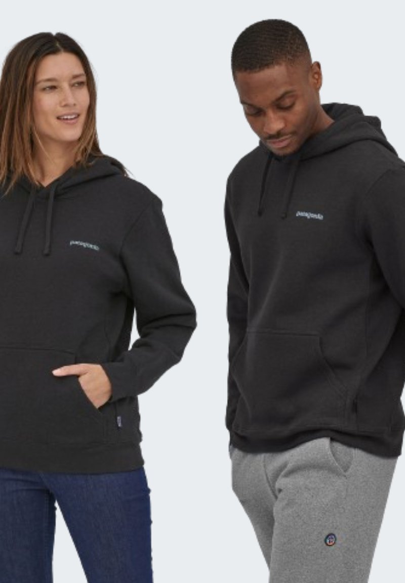 Felpa nera con tasca a marsupio e cappuccio con cordino. Presenta un logo azzurro chiaro sul petto. Indossata con pantaloni della tuta grigi.