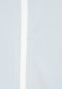 Világoskék szövet sima tapintással, fehér függőleges cipzárral a középen. Minimális dizájn és lágy megjelenés.