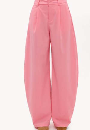 Pantalon rose taille haute à jambes larges avec plis sur le devant et poches latérales, stylisé avec des chaussures marron pointues.