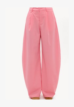 Pantalon rose taille haute à jambes larges avec plis sur le devant et poches latérales, stylisé avec des chaussures marron pointues.
