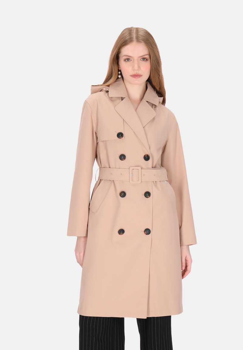 Trenci dublu beige cu nasturi mari negri, centură, guler și buzunare laterale. Textură netedă, mâneci lungi, design de lungime medie.