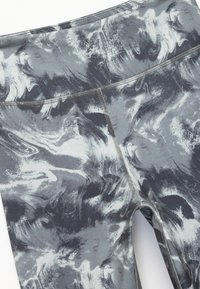 Marmorerede leggings i grå og sort stof med en glat tekstur. Har en høj talje og flade sømme for komfort.