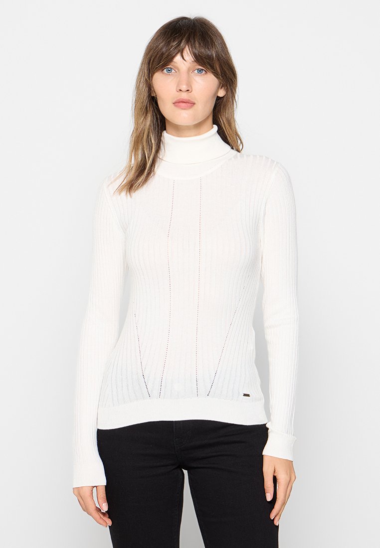 Jersey de cuello alto blanco con canalé y mangas largas, con rayas verticales y un diseño ajustado. Sutil acento cerca del dobladillo.