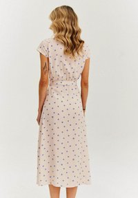 Różowa midi sukienka z krótkimi rękawami, fioletowe kropki, wcięcie w talii i gładki materiał, sięgająca do połowy łydki.