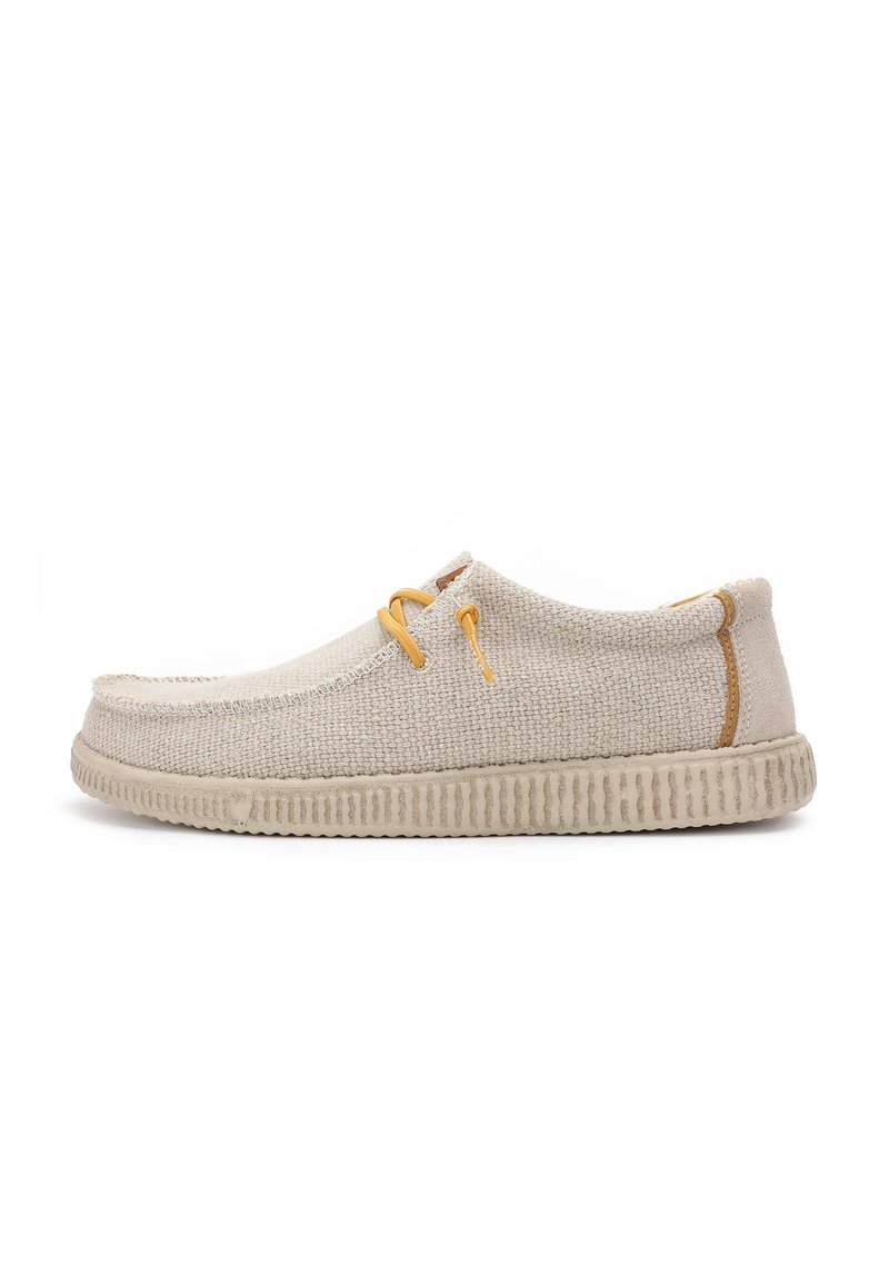 Bottines en toile beige clair avec une surface texturée, un bout rond, des détails cousus et des lacets jaunes. Elles sont dotées d'une semelle en caoutchouc nervurée.