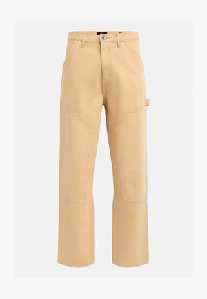 Beige cargo nadrág magas derékkal, széles lábakkal és feltűnő varrásokkal. Nagy oldalsó zsebekkel és övhurkol a jobb csípőn.