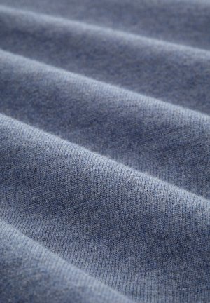 Țesătură textilă albastră cu o suprafață moale, tricotată, având șanțuri paralele care creează adâncime și un gradient subtil de culoare.