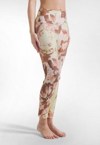 Leggings de cintura alta con un diseño floral que combina tonos durazno, marrón y verde. Confeccionados con tela elástica, presentan una silueta ajustada y largo hasta el tobillo.