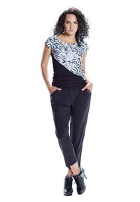 Black and white top featuring a tiger print, paired with black tapered pants. The outfit includes a smooth texture and fitted design.