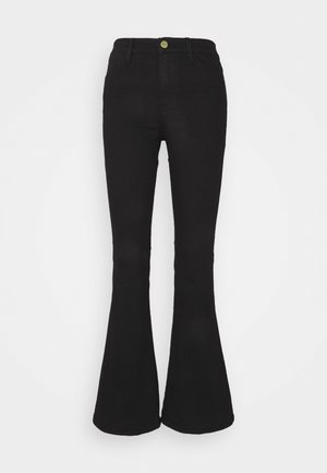 Jeans neri a zampa con vita aderente e apertura ampia alla gamba. Realizzati in denim con cuciture visibili e chiusura frontale con bottoni.