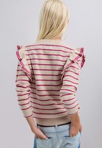 Suéter a rayas en beige y magenta con acentos con volantes en los hombros, puños acanalados y dobladillo. Tejido suave, diseño ajustado, estilo casual.