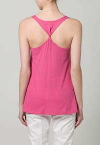 Różowy top bez rękawów o luźnym kroju, z wydrążonym tyłem i gładką teksturą materiału. Sylwetka jest uniwersalna, idealna na co dzień.