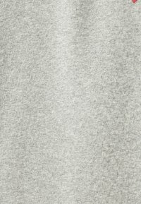 Grå heather sweatshirtstof med en blød tekstur, der har et lille rødt grafisk detalje. Overfladen virker let broget.